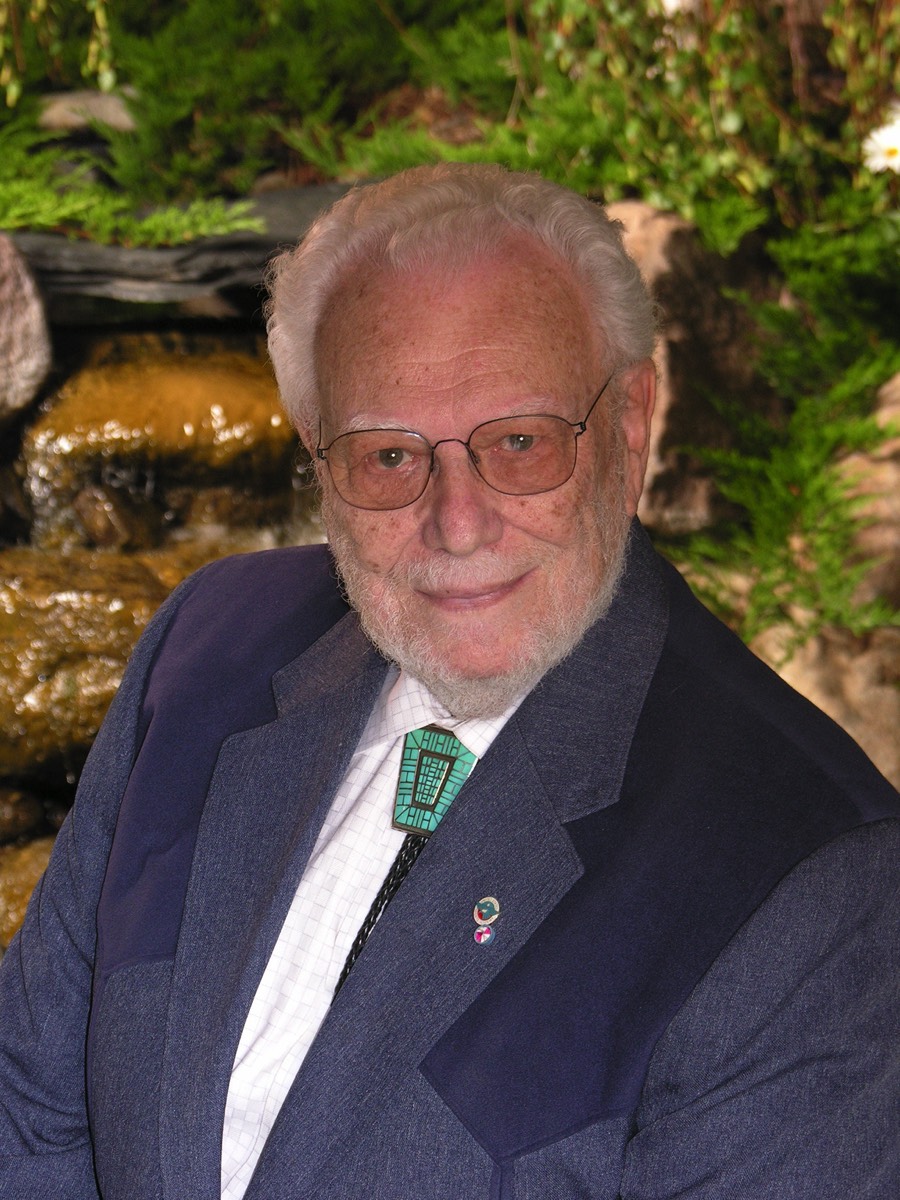 Robert Block sitting in front of a backyard waterfall.  He